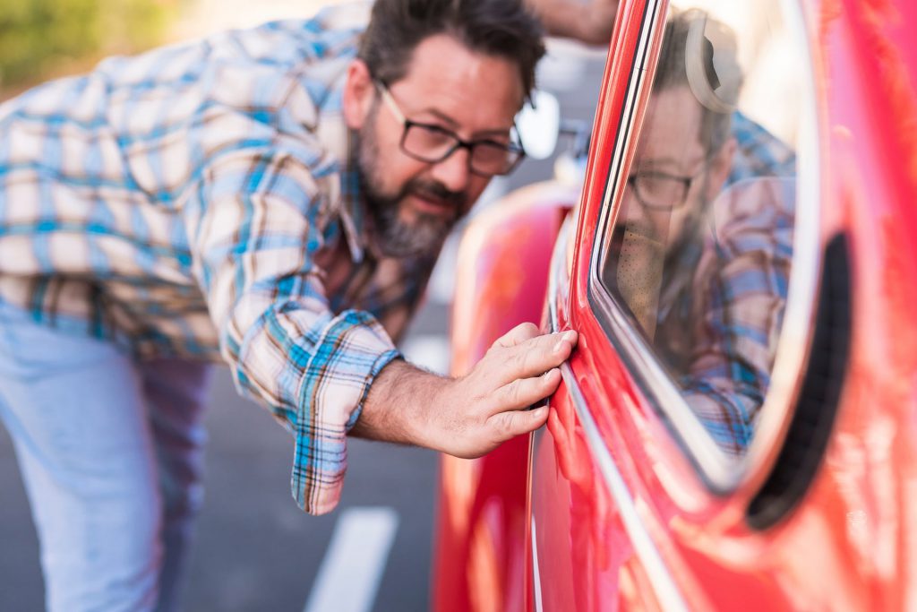 person checking a classic car